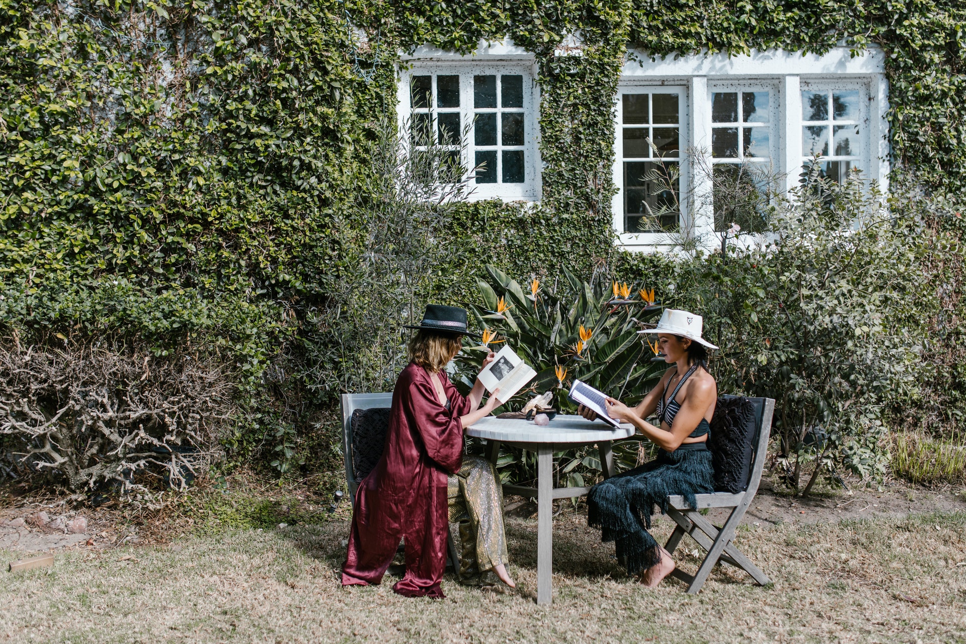 two girls reading book outside