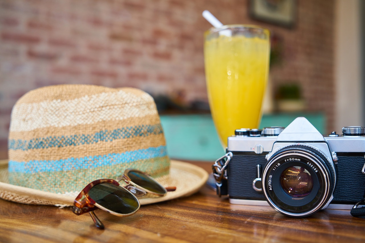 Orange juice,camera and summer hat
